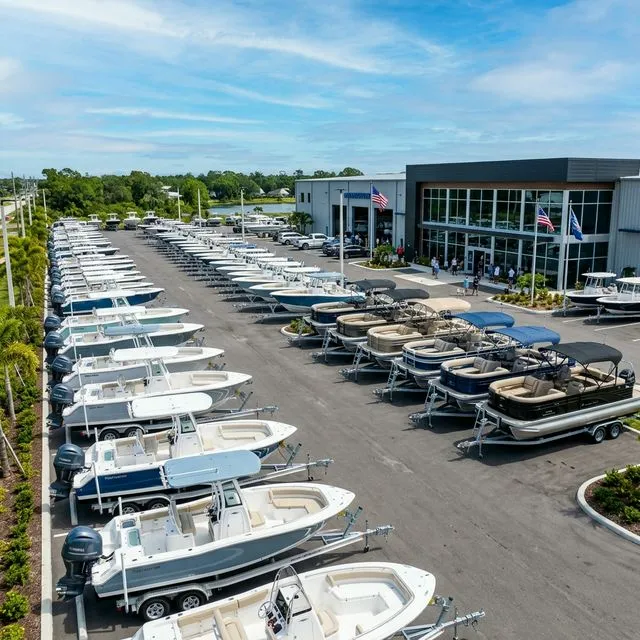 Large outdoor marine dealership lot filled with brand new boats on trailers
